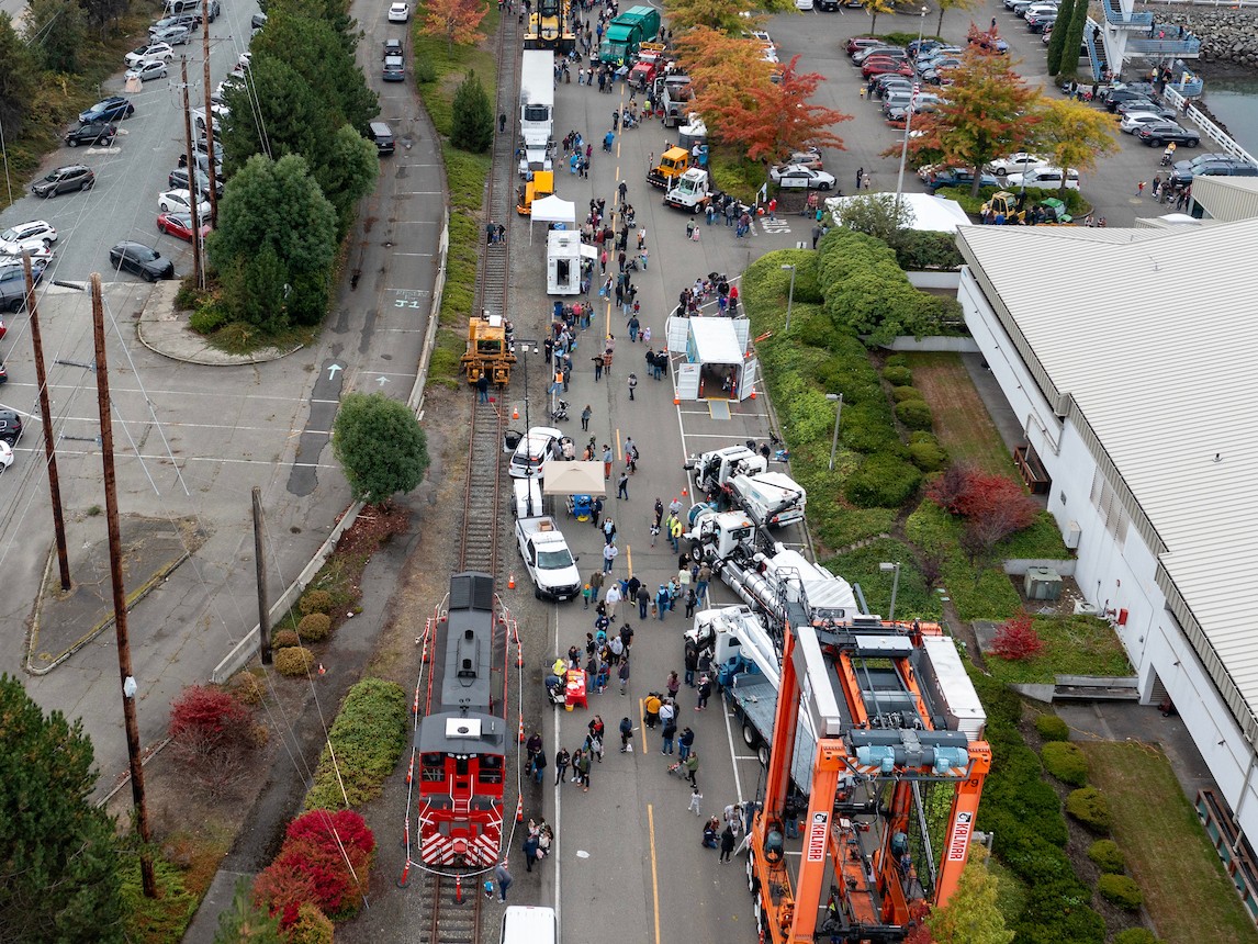 Aerial shot of a street lined with trucks and people moving through it. 